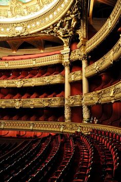 an ornately decorated auditorium with red seats