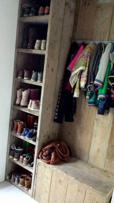 a wooden shelf filled with lots of shoes next to a white wall and window sill