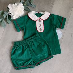 This Two Piece Baby Boy's Outfit Is Too Precious!! The Outfit Is Done Is A Kelly/Emerald Green 100% Cotton Pin Wale Corduroy. A Peter Pan Collar Is Done In A Contrasting White With Red Trim. The Center Of The Front Has Three Adorable Embroidered Gingerbread Men On A White Corduroy Background Trimmed In Red Cord Piping. The Short Sleeves Have A Faux Cuff Trimmed In Red Cord Piping. The Back Has A Button Closure. Matching Shorts Have An Elastic Waist With Slight Gathers In The Leg Openings Which A Green Cotton Sets For Holiday, Christmas Cotton Playtime Sets, Green Baby Shirt, White Knee Socks, Hunter Green Corduroy Toddler Long Sleeve, Cheer Costumes, Green Cotton Playtime Shorts, Hockey Outfits, Peter Pann Collar Dress Shirts Kids