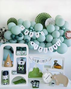 a birthday party with balloons, decorations and other items on the table in front of it