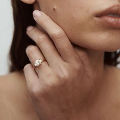 a close up of a person wearing a gold ring with a diamond on the middle