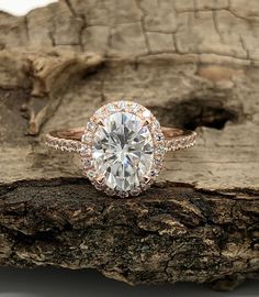 an engagement ring on top of a piece of wood with the center stone in the middle