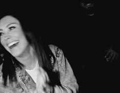 black and white photograph of a woman singing into a microphone