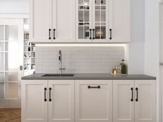 a kitchen with white cabinets and black counter tops