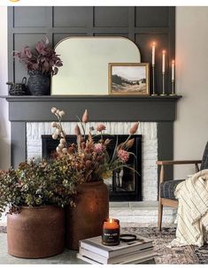 a living room filled with furniture and a fire place next to a fireplace covered in candles