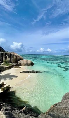 the water is crystal blue and clear with rocks on either side that are covered in sand