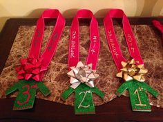 three ribbons with numbers and bows on them are sitting on a table in front of a wall