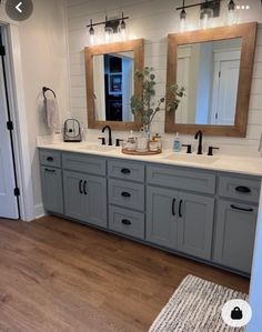 a bathroom with two sinks and mirrors on the wall next to a door that leads to another room