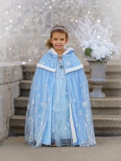 Delight in the splendor of our Princess-Themed Fleece Capes. Each cape is a masterpiece of imagination, perfect for storytelling, costume events, or adding an element of wonder to any festive occasion. Each cape is designed with a plush fleece interior for comfort and a luxurious tulle exterior sprinkled with glittering accents. A secure clasp ensures ease of wear for all ages. Blue Snowflake Cape - This regal cape, in a rich Sky blue, boasts a cascade of sparkling snowflakes, evoking the sereni Ice Princess Costume Kids, Christmas Blue Princess Dress, Blue Christmas Princess Dress For Dress-up, Snow Princess Dress Infant, Blue Hooded Winter Cape, Capes For Kids, Blue Snowflakes, Royal Princess, Cloak