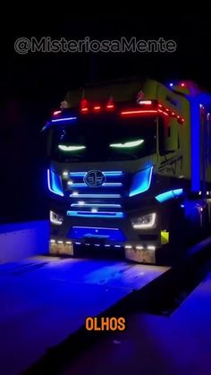 a semi truck with its lights on driving down the road