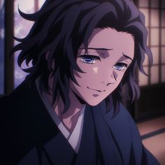 a man with long black hair and blue eyes staring at something in front of him