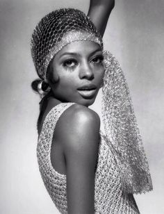 a black and white photo of a woman wearing a head scarf