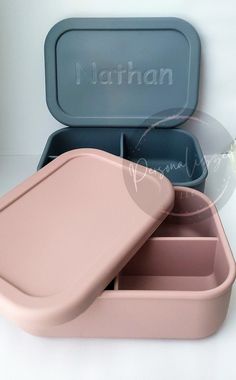 two pink and blue containers with lids sitting next to each other on a white surface