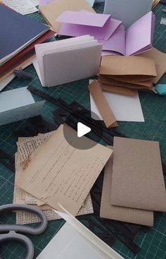 several pieces of paper are laying on the table with scissors and other crafting supplies