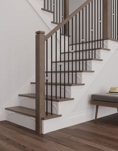 a white staircase with wooden handrails next to a gray bench and brown wood flooring