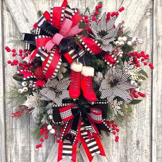 the wreath is decorated with red, black and white ribbons and snowflakes