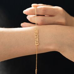 a woman wearing a gold bracelet with the word hope on it and a chain attached to her arm