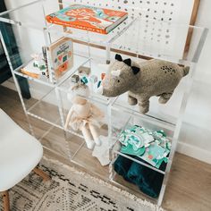 stuffed animals and books are on display in a clear case