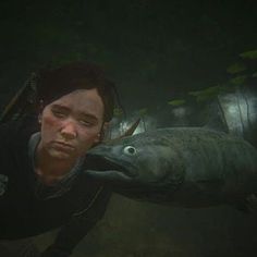 a man is holding onto a fish in the deep water, with another person looking on