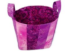 a purple and pink bag with flowers on it's side, sitting in front of a white background