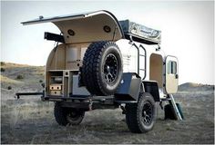 an off road camper with the roof down and its cargo compartment open on wheels