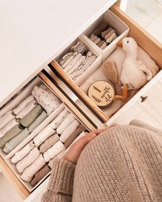 a woman is looking at the open drawers in her closet