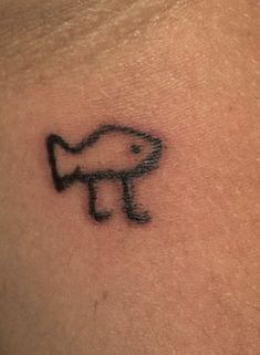 a small tattoo on the back of a woman's neck with an image of a fish coming out of it