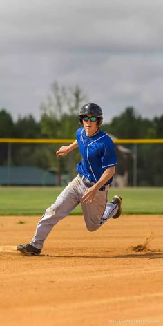 a young man running to base on a baseball field