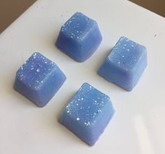 four pieces of blue soap sitting on top of a white counter