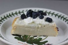 a piece of pie with whipped cream and blueberries on it sitting on a plate