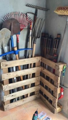 a wooden crate filled with gardening tools on top of a floor next to a wall