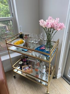 a gold bar cart filled with glasses and bottles