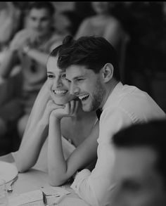 a man and woman sitting at a table smiling