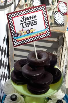 chocolate donuts are stacked on top of each other in front of a sign that says spare tires