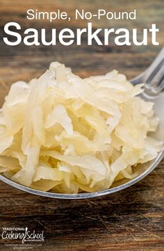 a spoon with sauerkraut in it on top of a wooden table and the words simple, no - pound sauerkraut