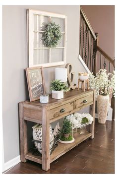 a wooden table topped with plants next to a stair case