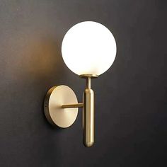 a light that is on the wall next to a black wall with a white ball