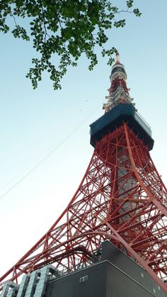 a tall red tower with a clock on it's side