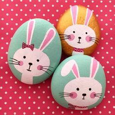 three painted rocks with bunny faces on them