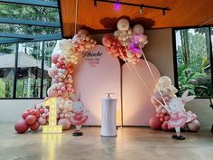 balloons and decorations are on display in front of large windows at the entrance to an indoor venue