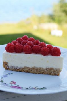 a piece of cheesecake with raspberries on top is sitting on a plate