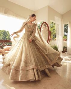 a woman in a wedding dress is posing for the camera