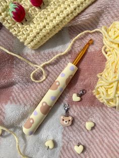 knitting supplies are laid out on a pink and white blanket next to a crochet bag