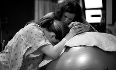 two women hugging each other while sitting on an exercise ball in black and white photo