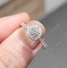 a close up of a person's hand holding a diamond ring