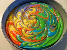 a colorful cake in a metal pan on a counter top with swirls painted all over it