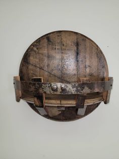 an old wooden barrel mounted to the wall with metal straps on it's sides