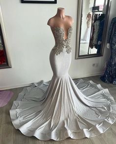 a white wedding dress on display in front of a mirror