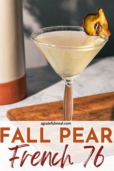 a close up of a drink in a glass on a table with the words fall pear french 75