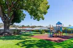 a park with a playground and trees in the background